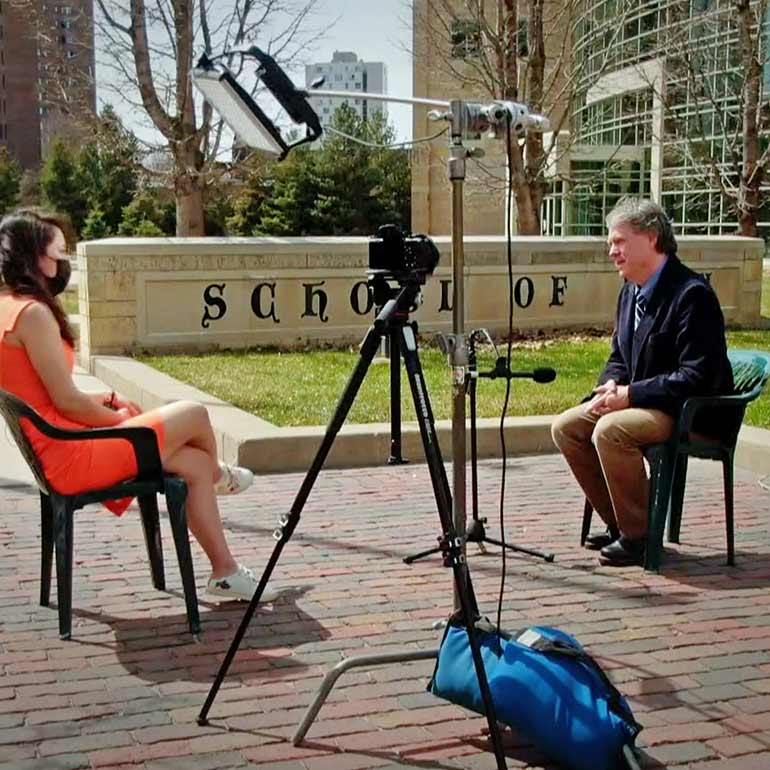Law professor Mark Osler gives an interview in front of the Minneapolis campus.