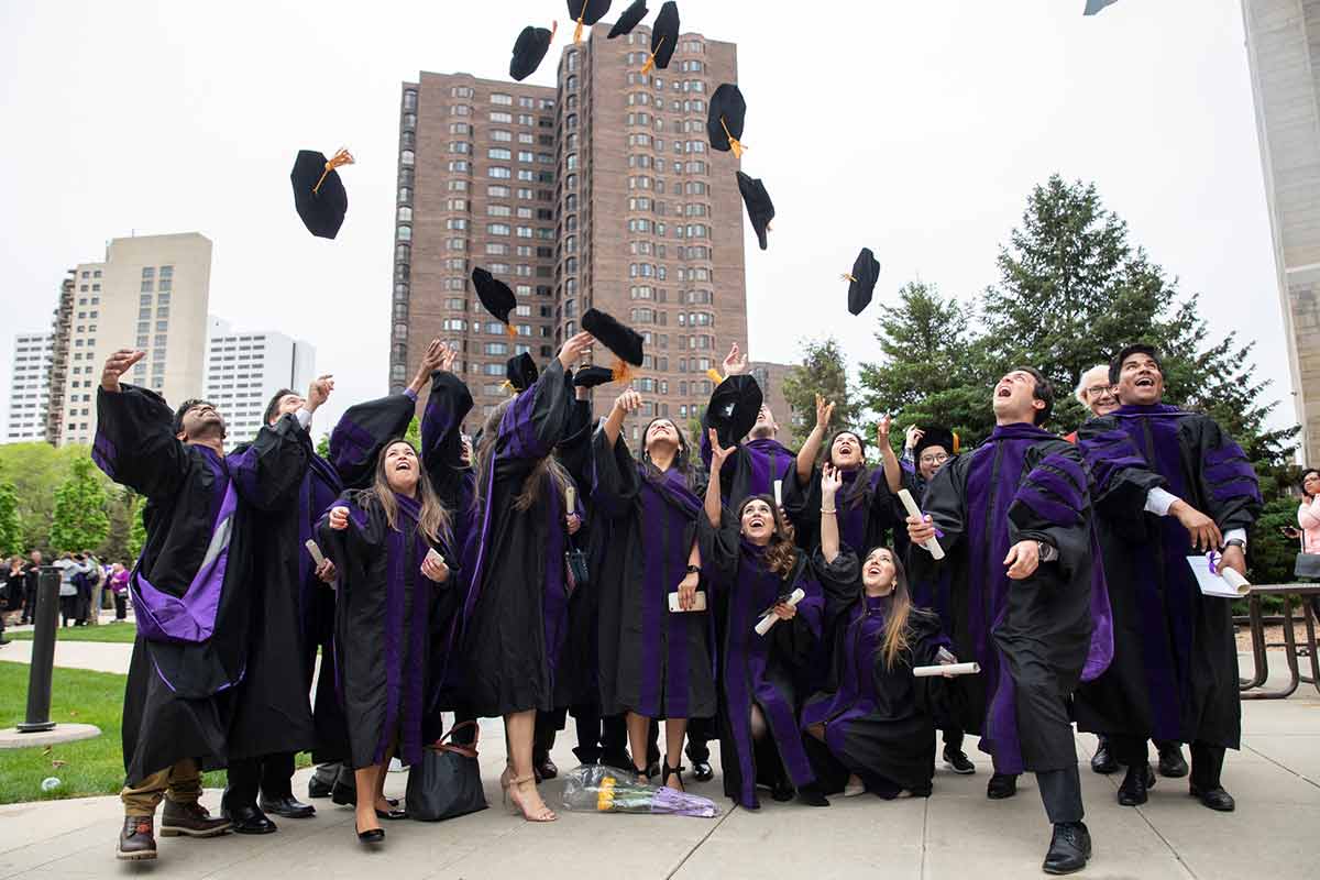 Graduating students throw caps into the air.