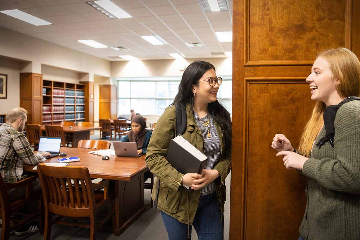 Master students chat in the library